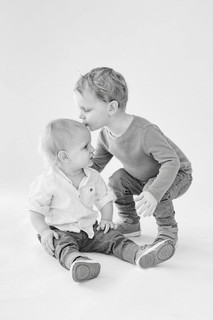 Sibling brothers attend Milestone 1st Birthday Photos by Plymouth Michigan Newborn Photographer at Studio Neue in Plymouth Michigan