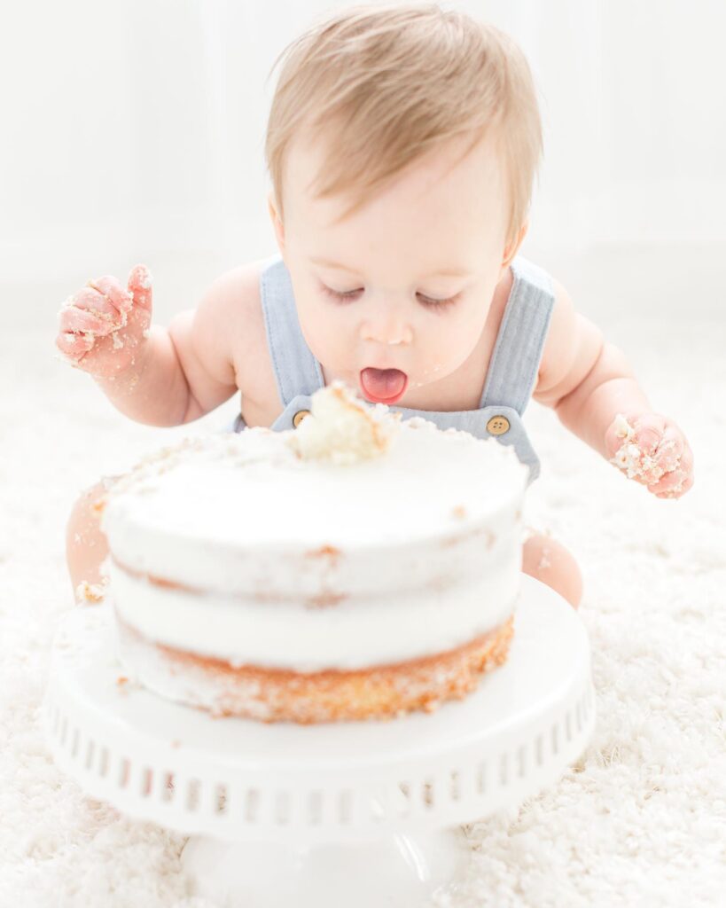 Baby boy dives into cake at his 1st birthday milestone session taken by Plymouth Michigan Newborn Photographer at Studio Neue