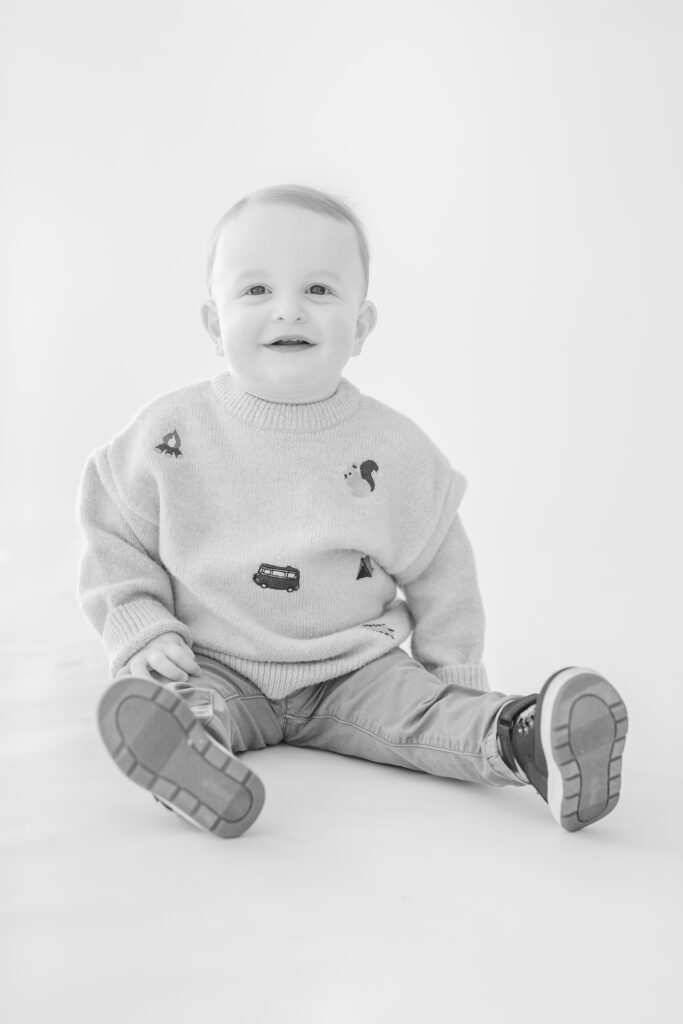 Baby Boy smiles for the camera at his Mini Session at Studio Neue in Plymouth Michigan put on by Plymouth Michigan Newborn Photographer